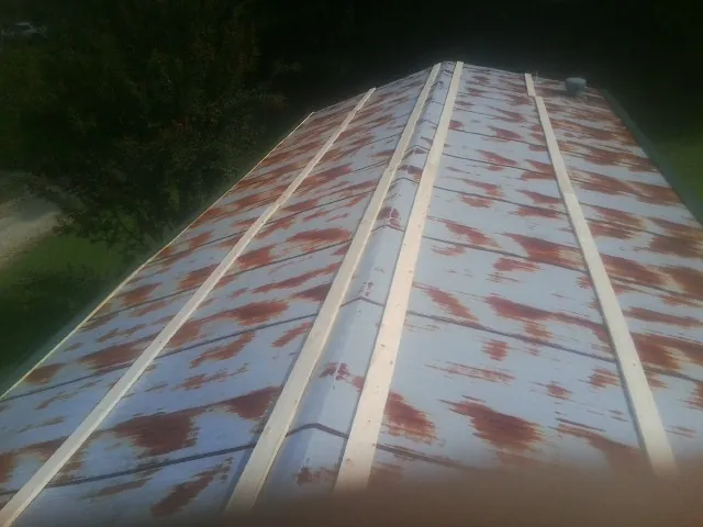 Rusted metal roof panels with new wood purlins before replacement — Storm Damage Roof Repair in Amma by Roofing Brothers