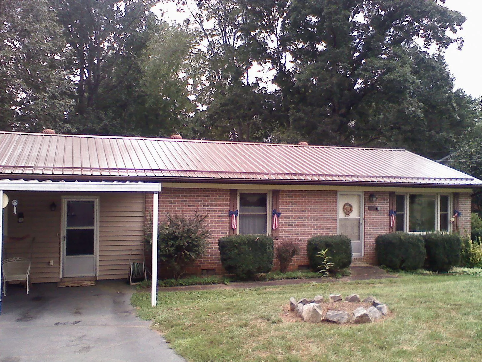 Bronze metal roof and carport on a brick ranch home — Roof Repair work by our crew in Amma